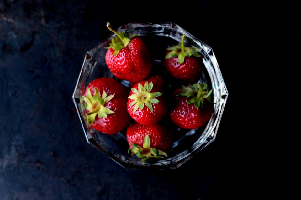 red strawberries in clear glass bowl