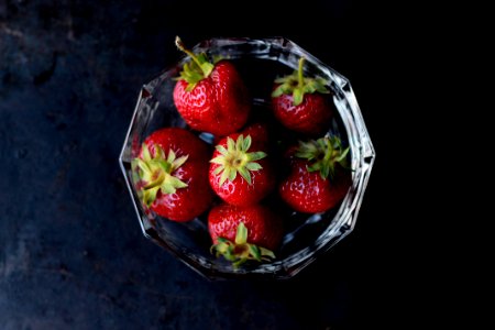 red strawberries in clear glass bowl