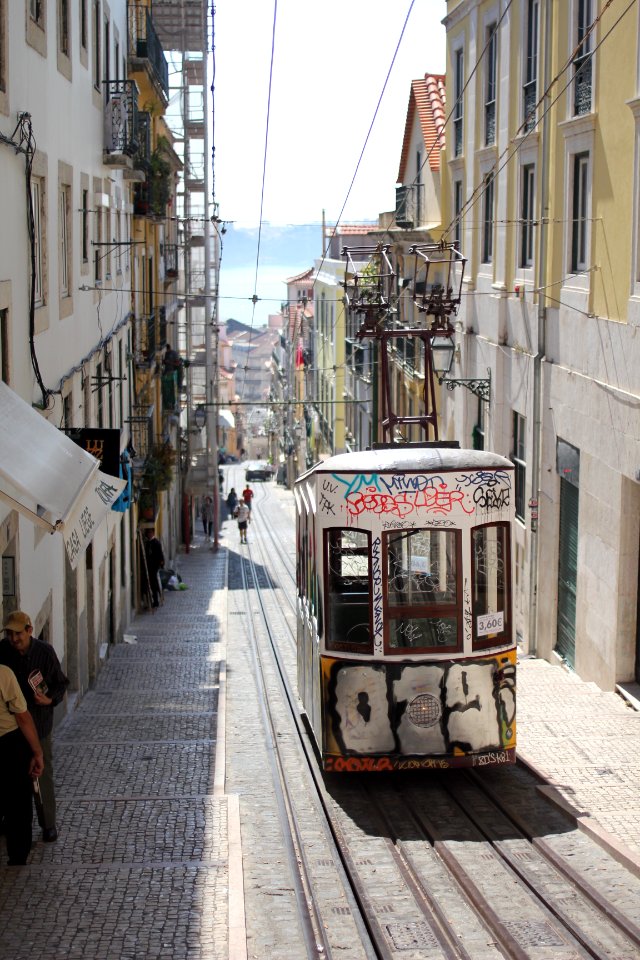 gray tram on railway along the building