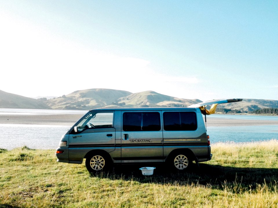 silver van parked on green grass field