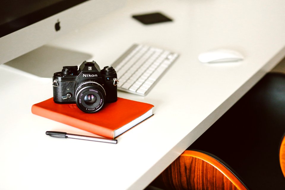 black Nikon DSLR camera on red notepad