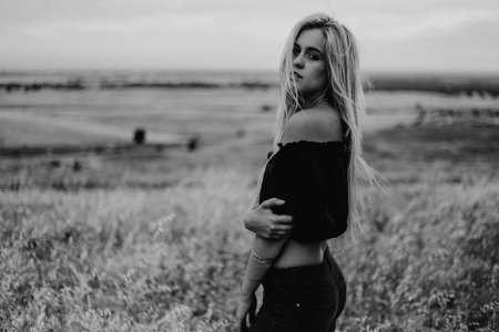 woman in black off-shoulder crop-top standing on grass field photo