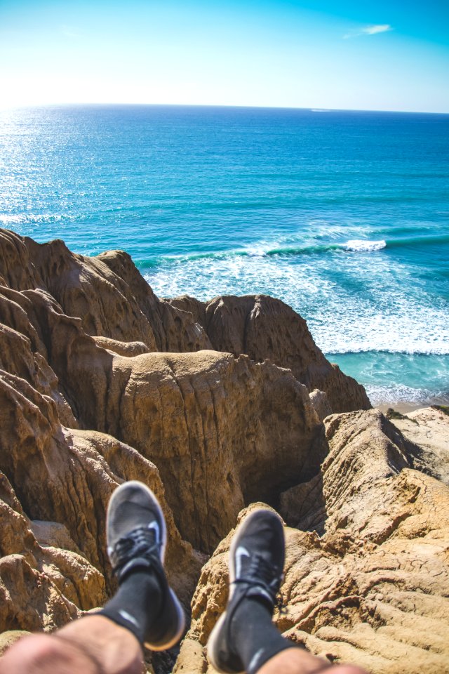 person sitting on cliff photo