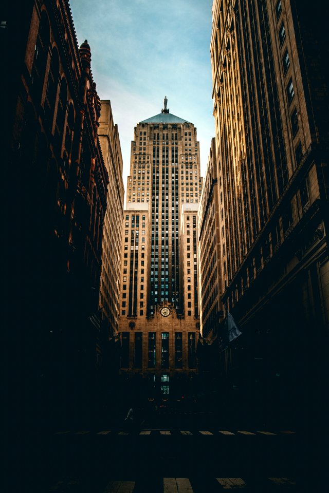 low angle photography of road straight to high-rise building under white and blue cloudy skies photo