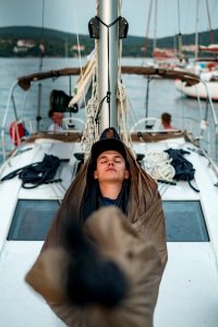 man sleeping on boat hammock photo