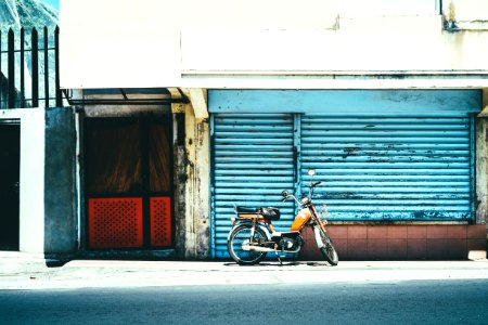 orange motorcycle near blue shutter gate photo