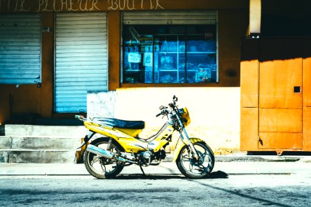 yellow motorcycle parked outside store photo