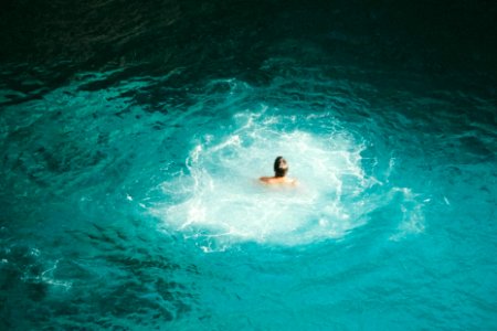 photo of person swimming on body of water photo