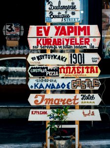 beige, red, and brown signages on beige stand at daytime photo