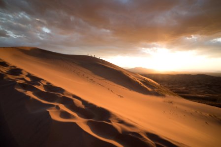 group of people walking on desert during dawn photo