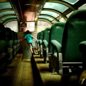 boy walking inside bus with green seats photo