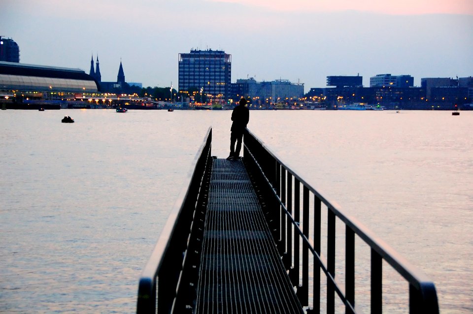 silhouette of person standing on metal dock