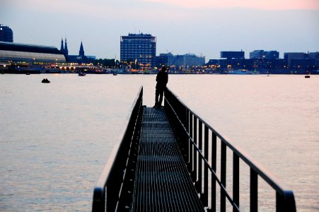 silhouette of person standing on metal dock