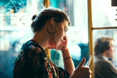 woman listening using white earphones photo