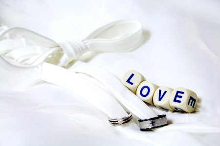 White material tied in a bow, with little cubes that say "Love." photo