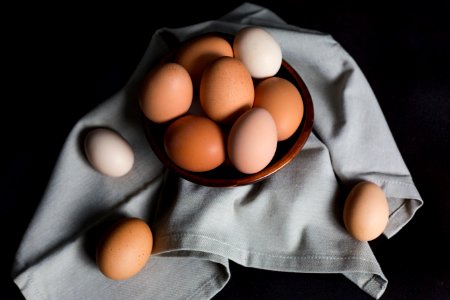 beige and white eggs on brown wooden bowl photo