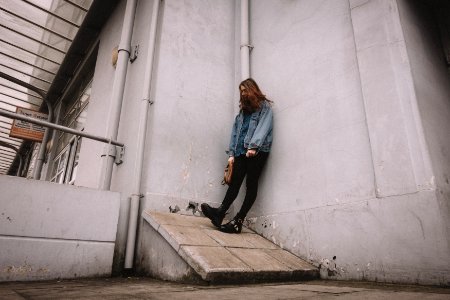 man leaning on gray concrete wall photo