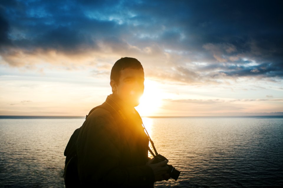 man standing near body of water during daytime photo