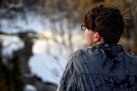 depth of field photography of man wearing gray collared shirt and eyeglasses photo