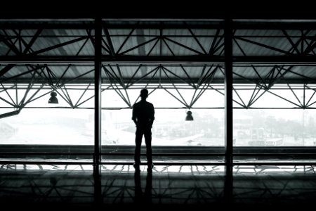 silhouette of man standing between two posts photo