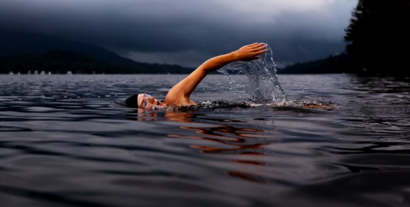 man swimming on body of water photo