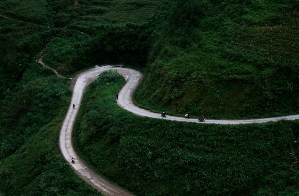 aerial view of curved road beside mountains during daytime photo