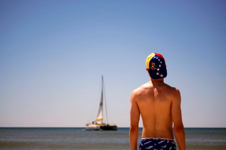 man standing facing boat during daytime photo