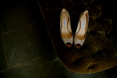 pair of brown gray leather open-toe heeled shoes on tufted mattress