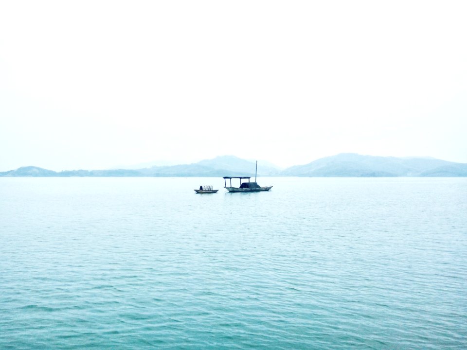 two white boats in middle of sea during daytime