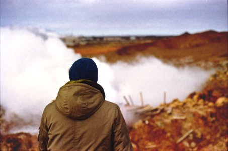 person in brown hooded jacket standing near fog photo