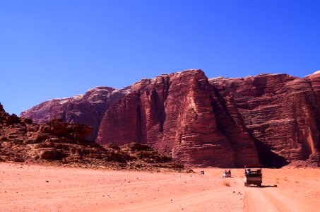 group of people traveling to desert field near to mountain photo