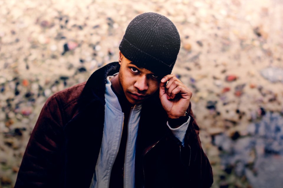 selective focus photo of man wearing brown coat and beanie photo