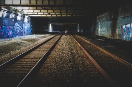 person standing in the middle of train rail tracks photo