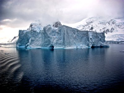 white iceberg near white mountains photo