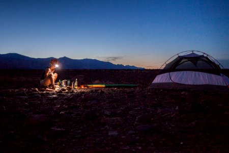 person camping beside white and black tent photo