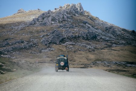 green Jeep on grey asphalt road photo