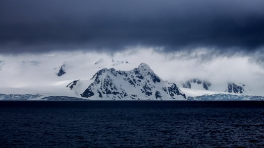 snow-covered mountain near body of water photo