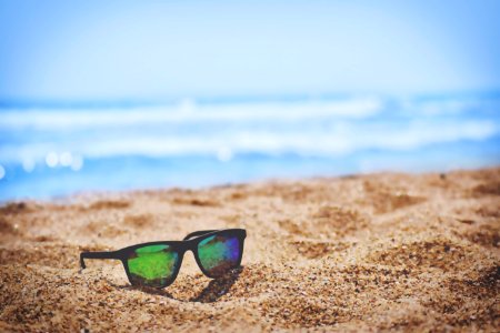 wayfarer sunglasses on beach sand during daytime photo