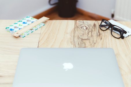 silver MacBook on beige table photo