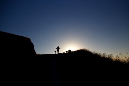 silhouette photo of person above hill photo