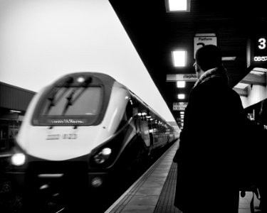 man standing beside moving train photo