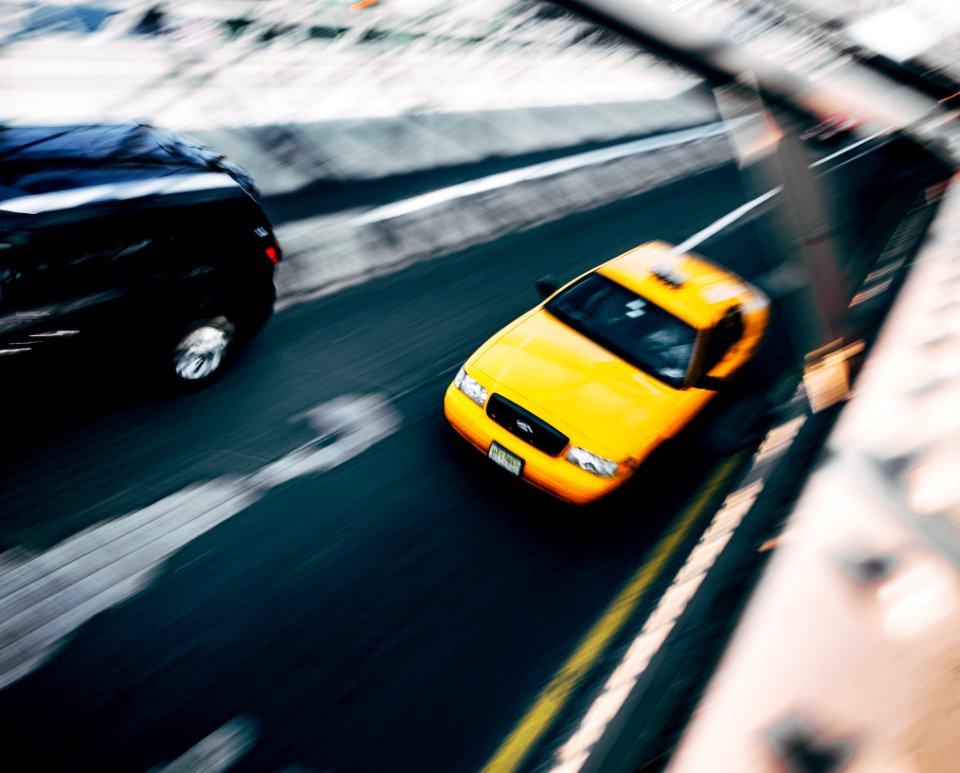 A yellow taxi driving.