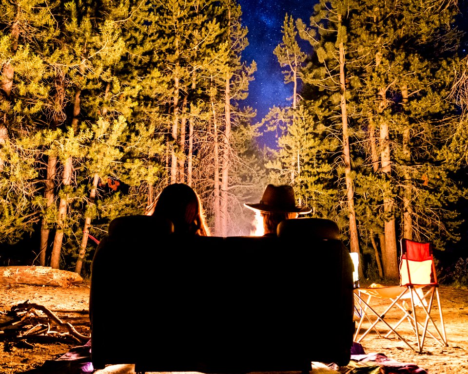 man and woman in front of campfire