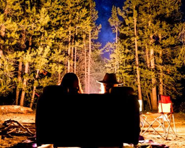 man and woman in front of campfire photo