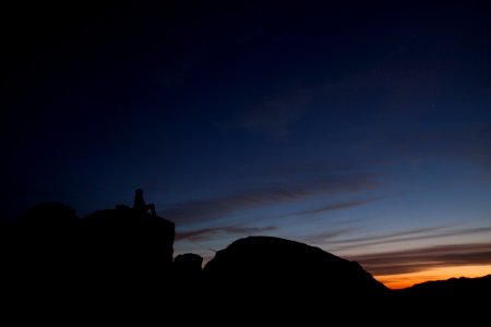 silhouette of person sitting during sunset photo
