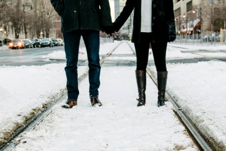 photo of two person standing on snow-covered road photo