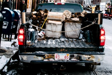 pickup truck loaded by firewood while parked on concrete roadway