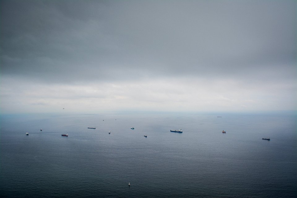 boats on calm sea under dim sky