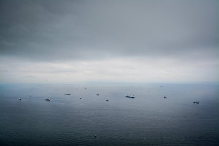 boats on calm sea under dim sky photo