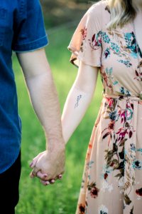 selective focus photography of man and woman holding there hands photo